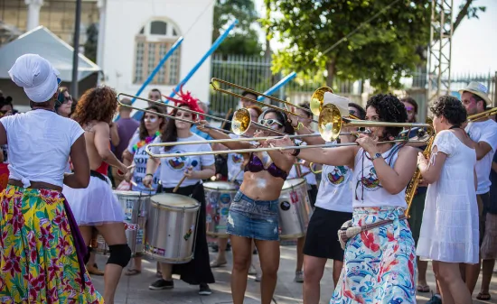 Women play brass instruments in a square in Rio